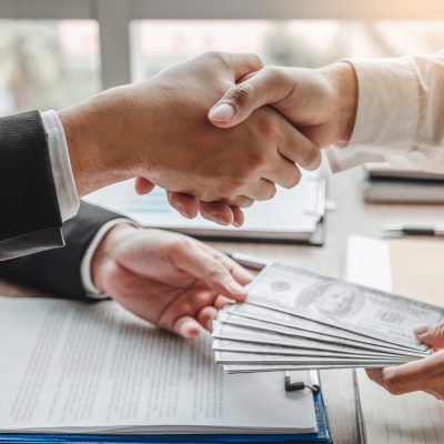 Corruption,And,Bribery,,businessman,Shaking,Hands,Giving,Dollar,Bills,Corruption